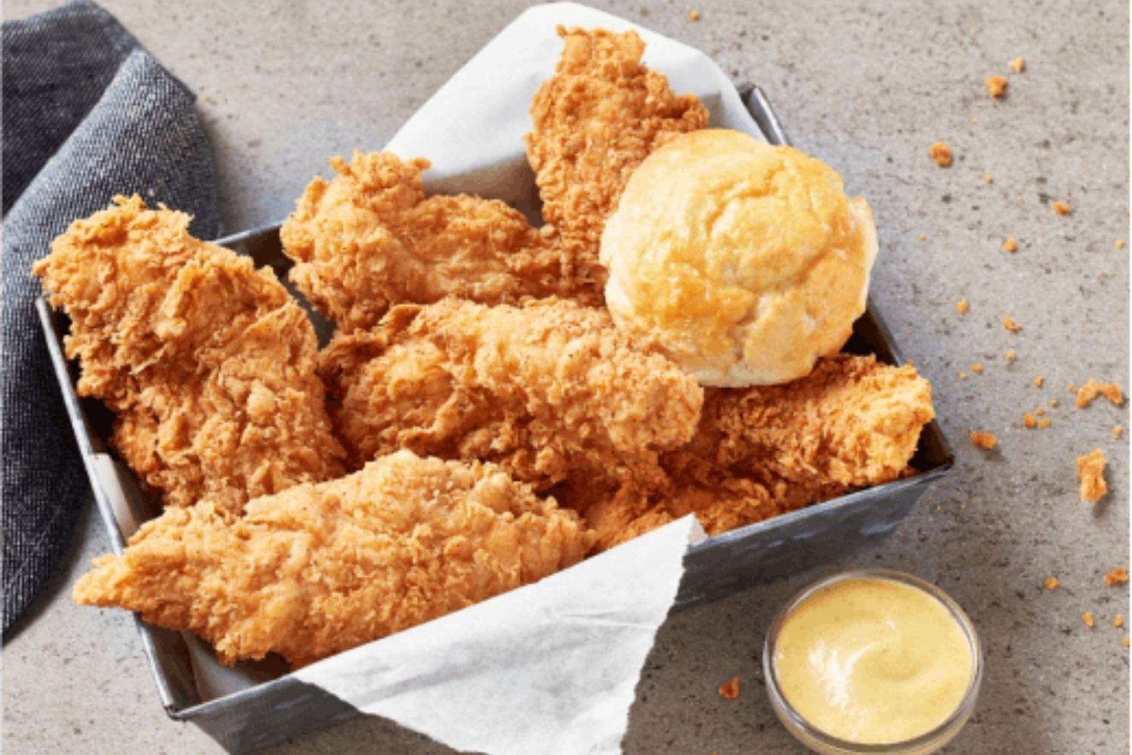Fried chicken tenders with a soft biscuit and dipping sauce at Krispy Krunchy Chicken - Halal, a Fast - Food in Richardson