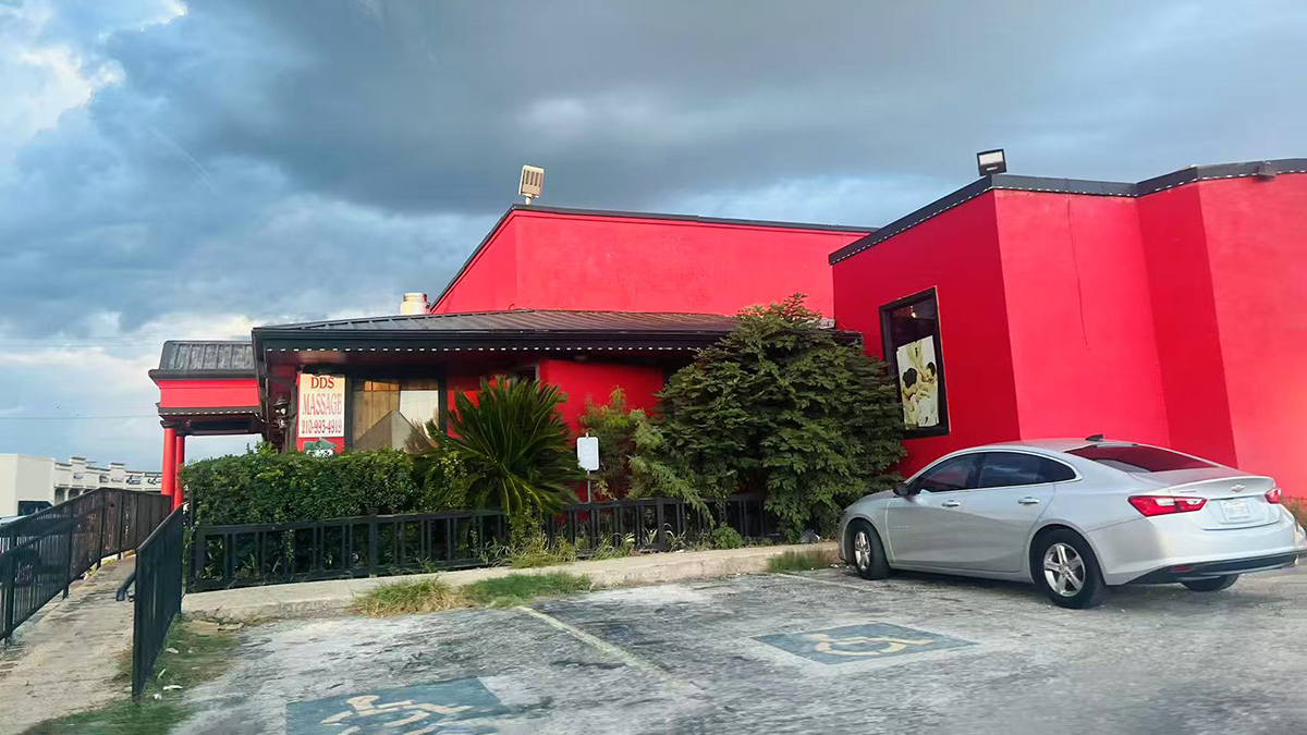 Kobe-Japanese-Steakhouse-Japanese-Restaurant-Exterior-San-Antonio Side view of a red restaurant building with a parked car