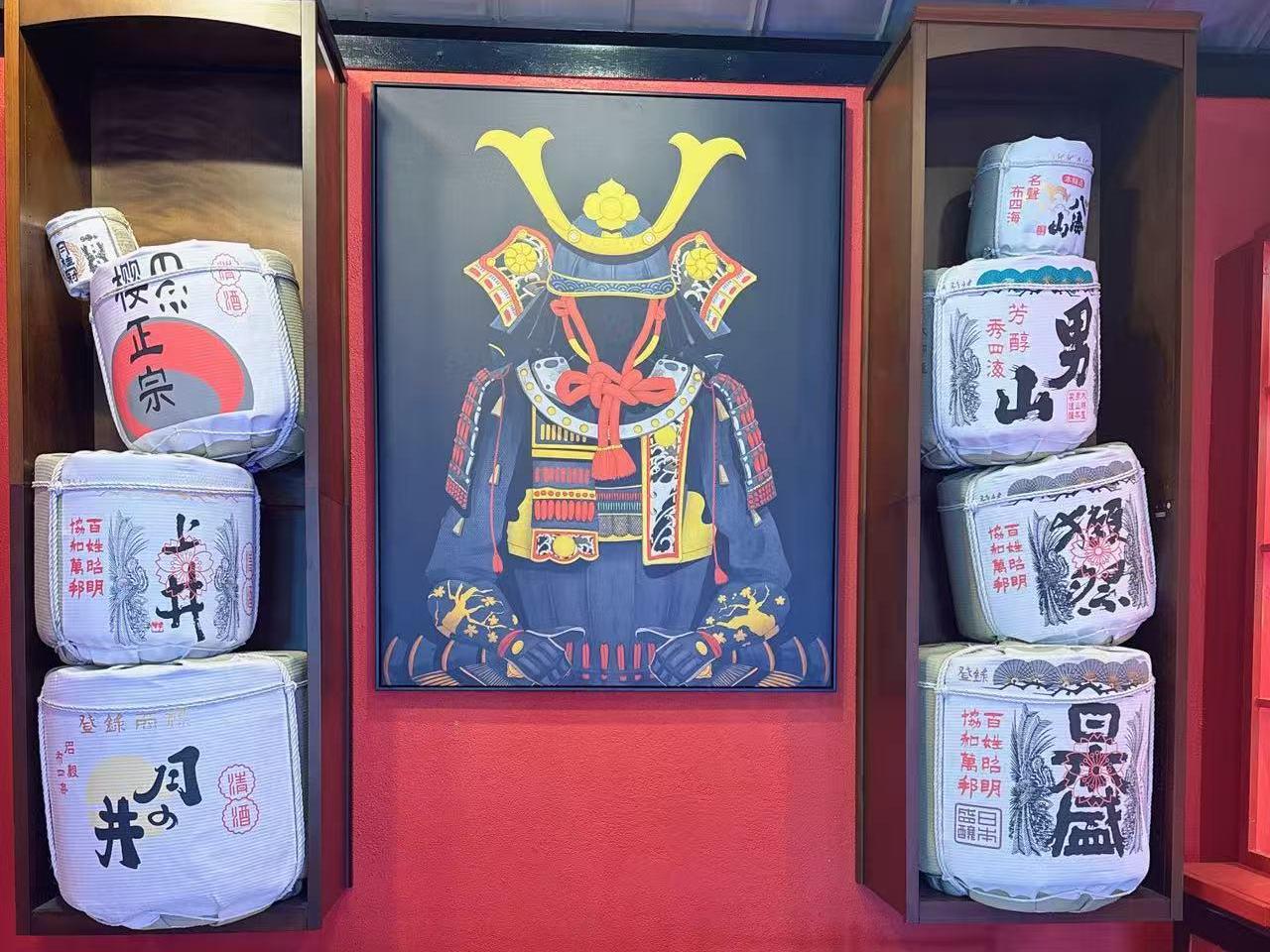 Samurai Art Display - A framed artwork of samurai armor flanked by sake barrels at Koi Ramen & Sushi, a Japanese Restaurant in Grand Junction