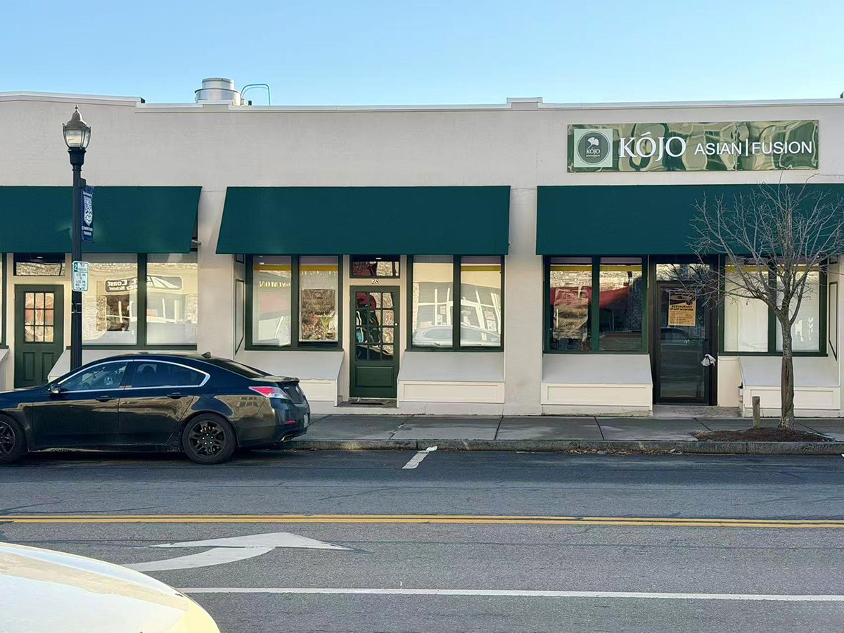 Street view of Kojo Asian Fusion restaurant's exterior with green awnings and logo sign