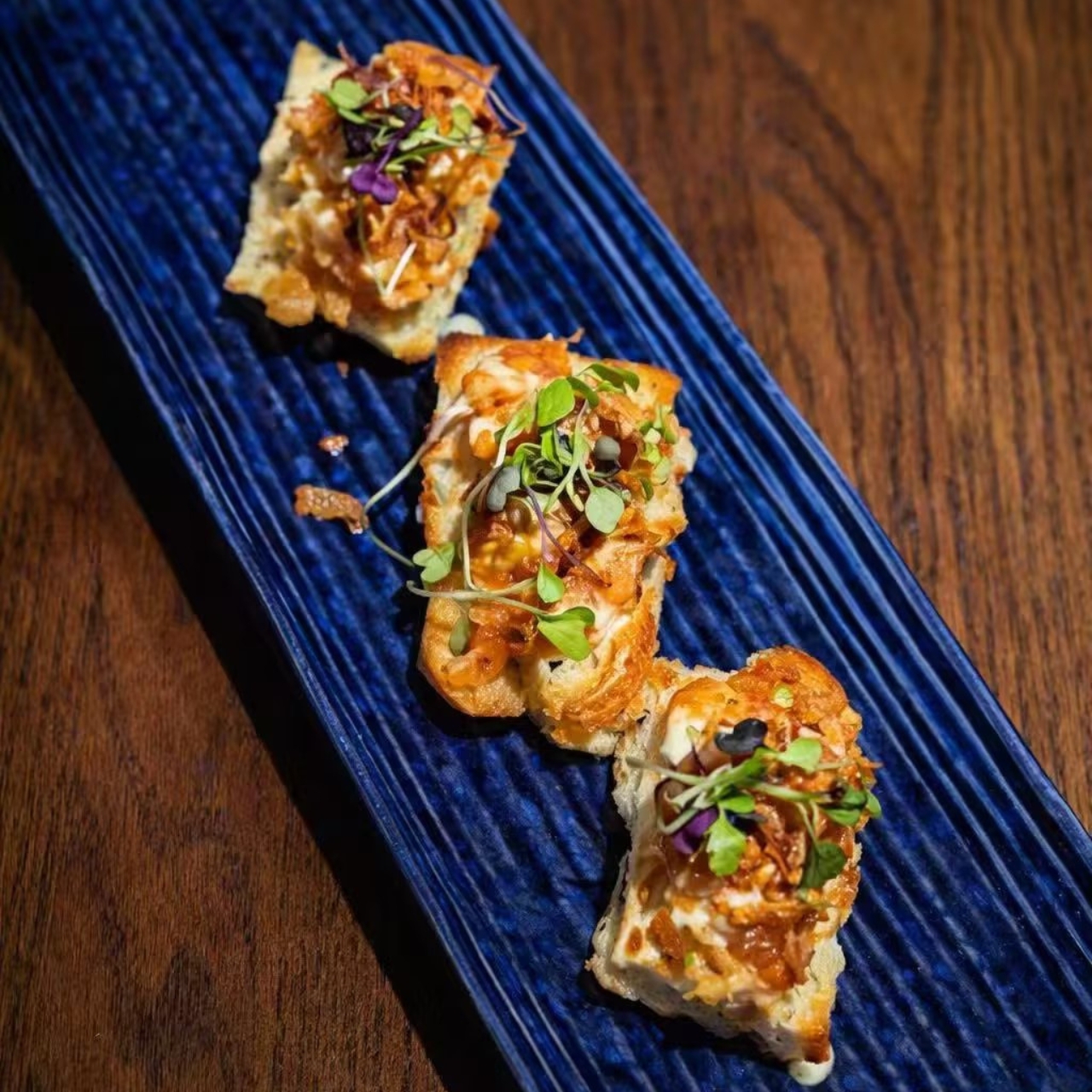 Toasted bread topped with seafood and microgreens at KOJO Asian Fusion, a Asian Fusion Restaurant in Franklin