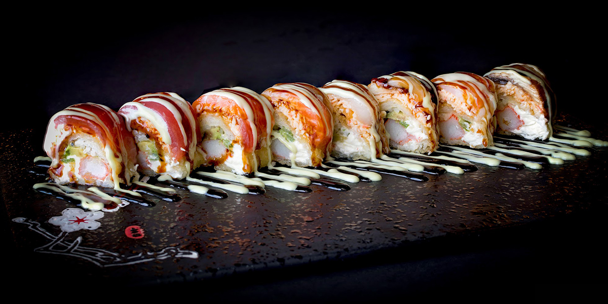 Tuna topped cream sauce seafood sushi roll platter at Komeya Sushi & Ramen, a Japanese Restaurant in Spring