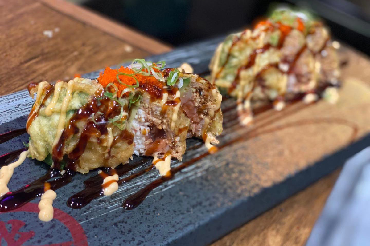 Fried tempura wrapped seafood sushi with dual savory sauces at Komeya Sushi & Ramen, a Japanese Restaurant in Spring