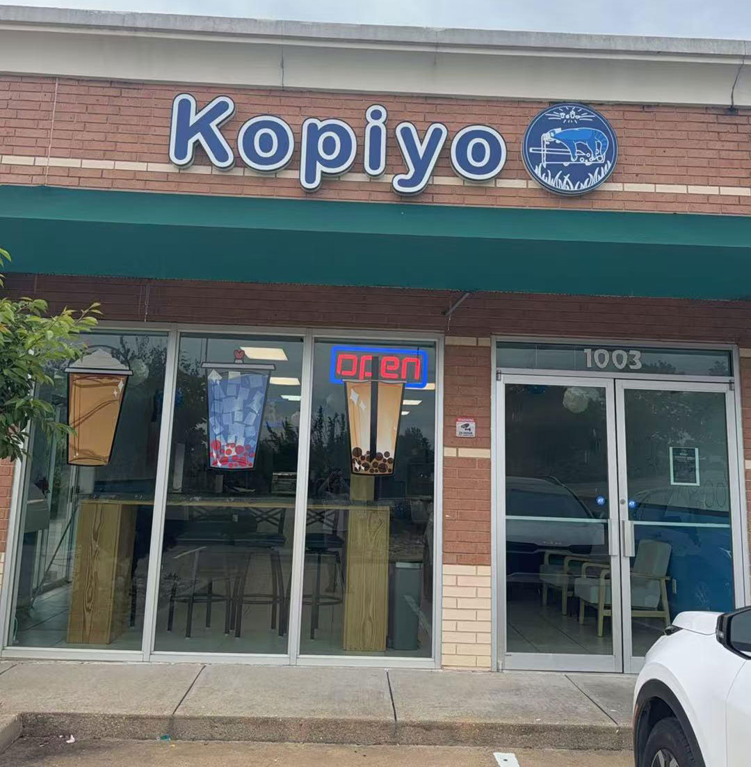 Brick-front Kopiyo coffee shop exterior with open sign, logo, and bubble tea decals at Kopiyo, a Coffee shop in Flowood