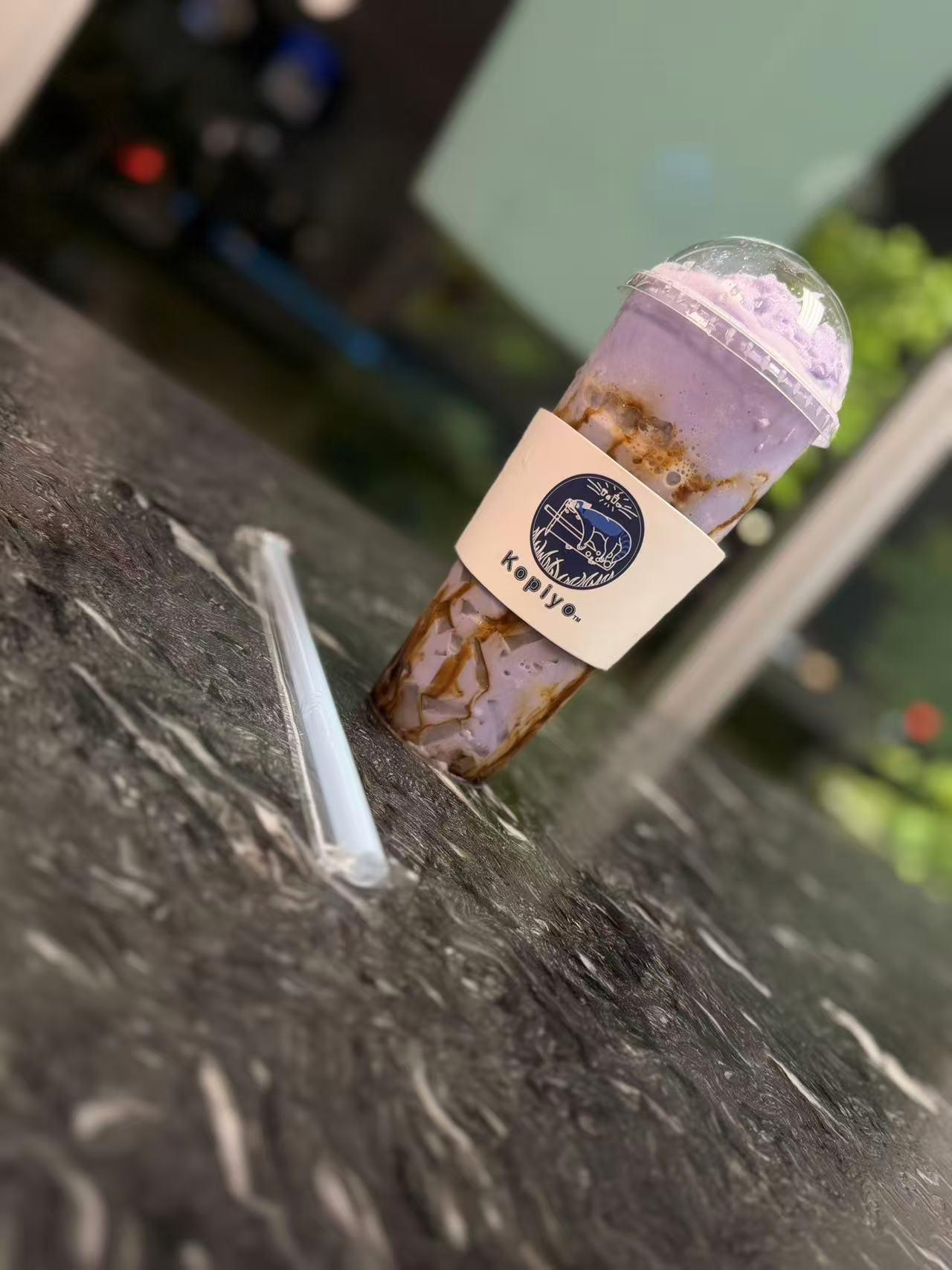Purple taro slush drink with brown drizzle in a Kopiyo cup at Kopiyo, a Coffee shop in Flowood