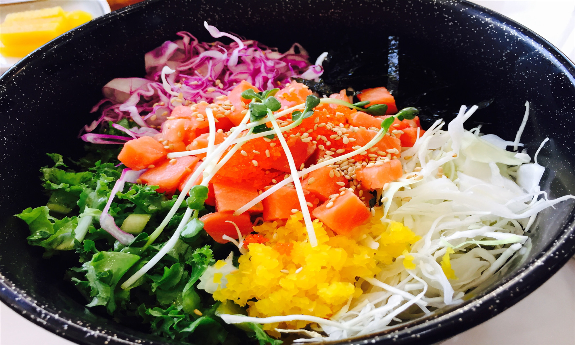 Salmon poke bowl with assorted vegetables and sesame seeds at Koya Sushi, a Japanese Restaurant in Whittier