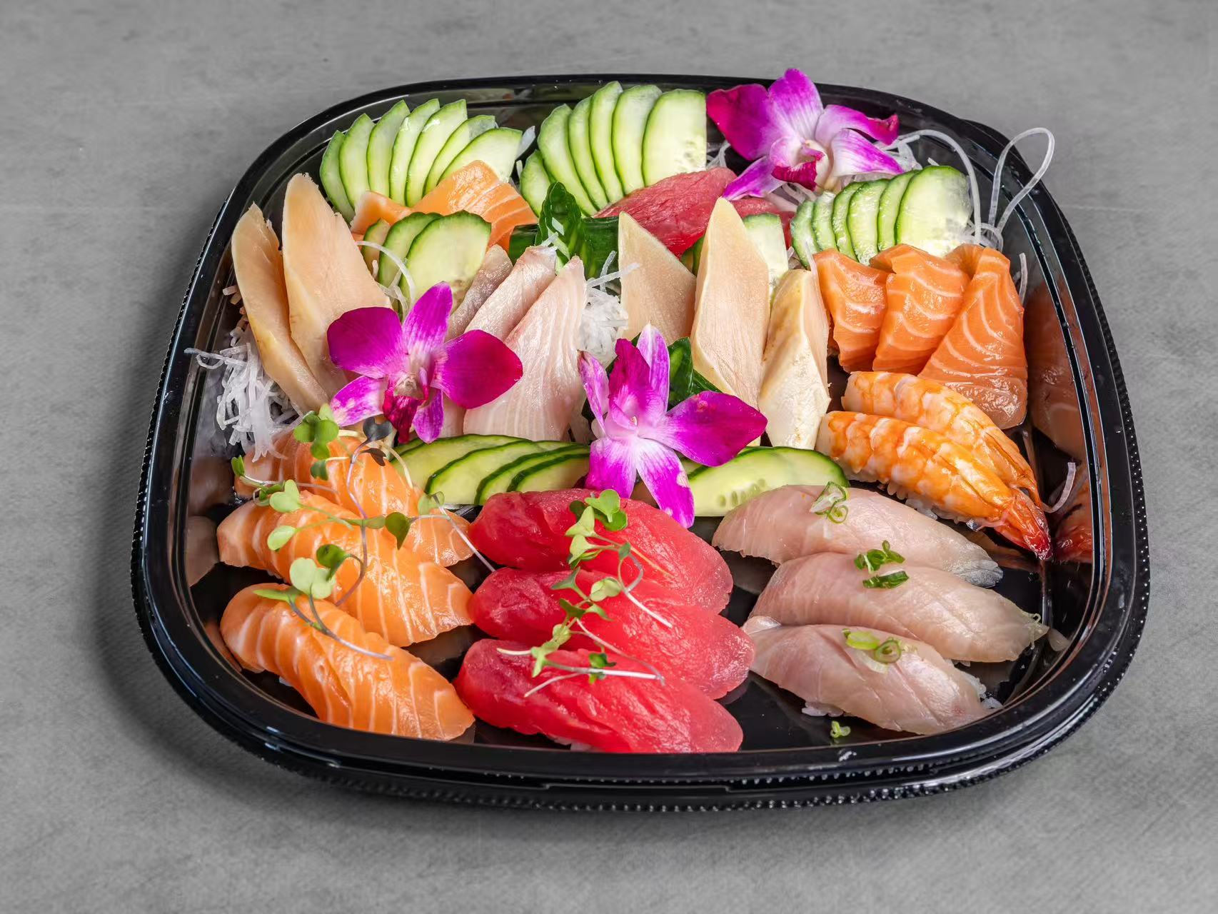 A platter of assorted sashimi with cucumber slices and purple orchids at Koya Sushi, a Sushi Restaurant in Norco