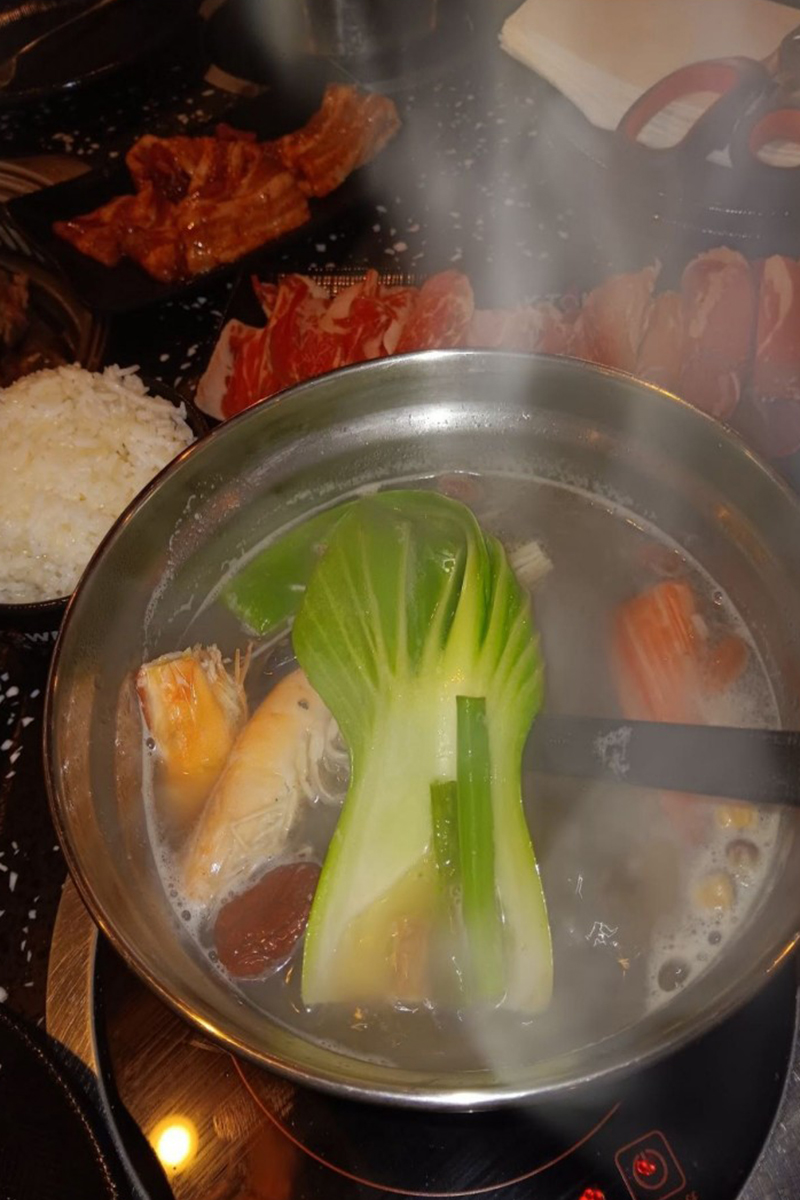 The pot is steaming hot, with ingredients such as vegetables at K-Town Korean BBQ & Hotpot, a Korean BBQ & Hotpot Restaurant in Fort Wayne