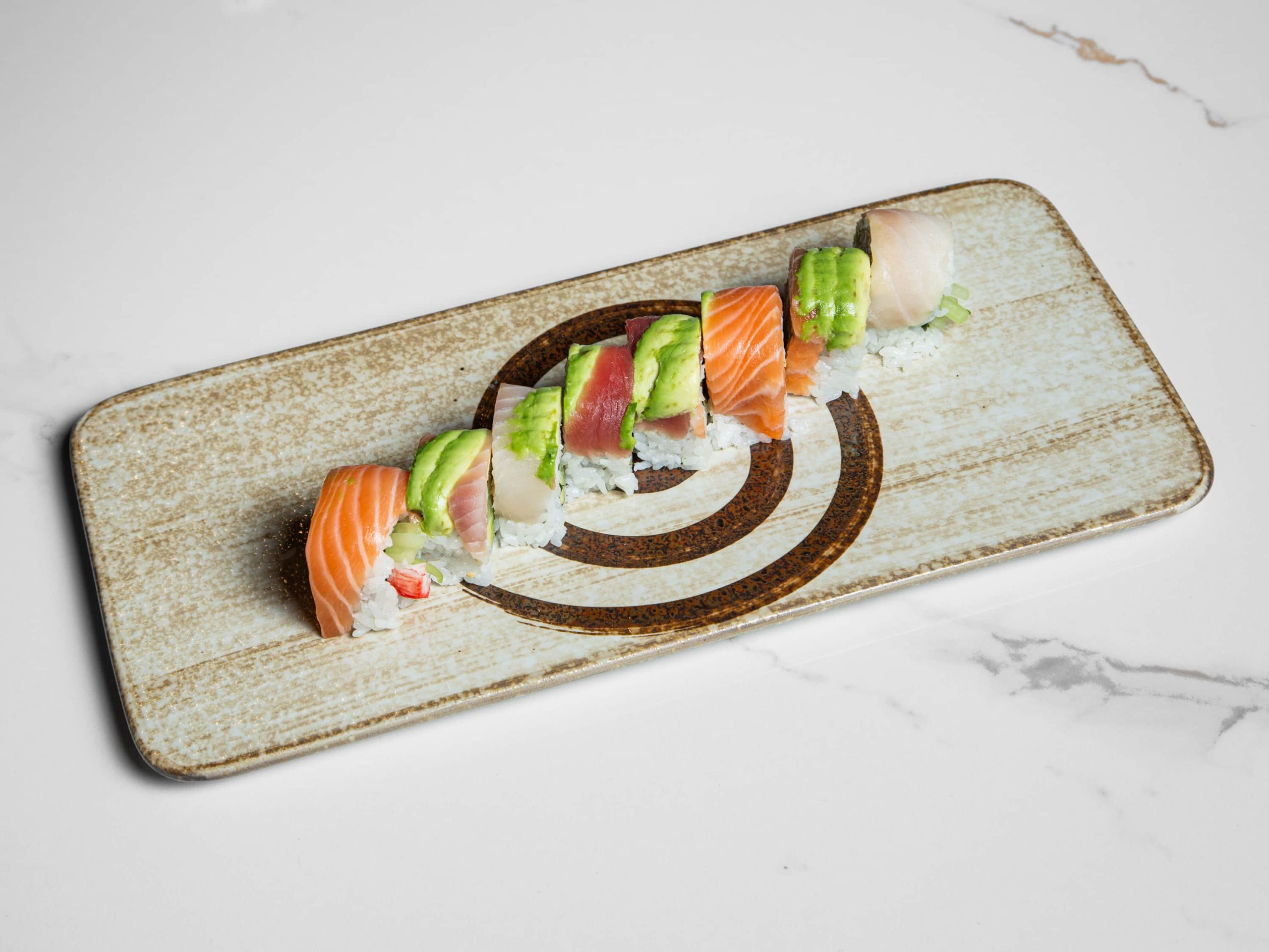 Colorful sushi roll with assorted fish and avocado at Kuchi, a Buffet Restaurant in Tampa