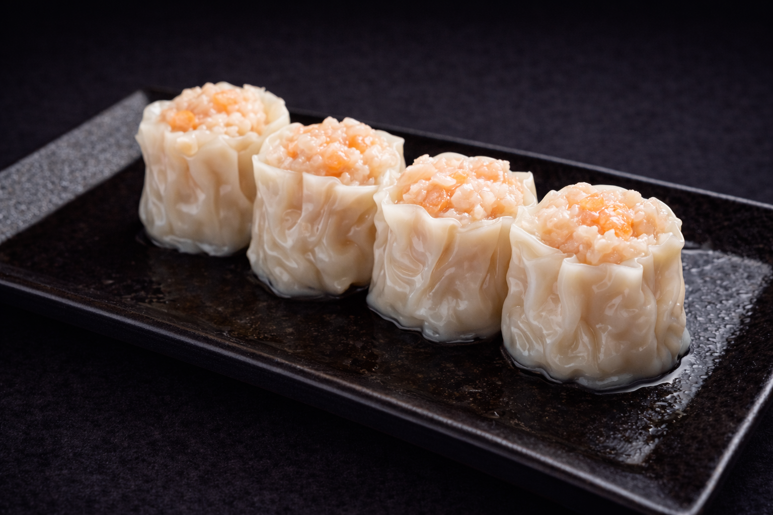 Shrimp siu mai dumplings on a black plate at Kuchi buffet, a Sushi restaurant in Tampa