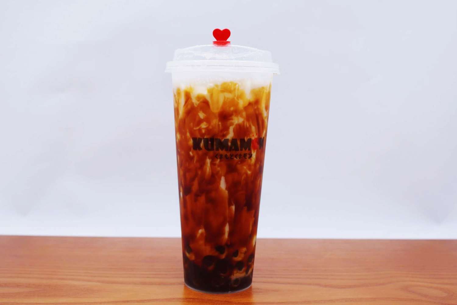 Iced bubble tea with tapioca pearls in a tall plastic cup at Kumamon Sushi & Ramen AYCE, a Japanese Restaurant in Wilmington