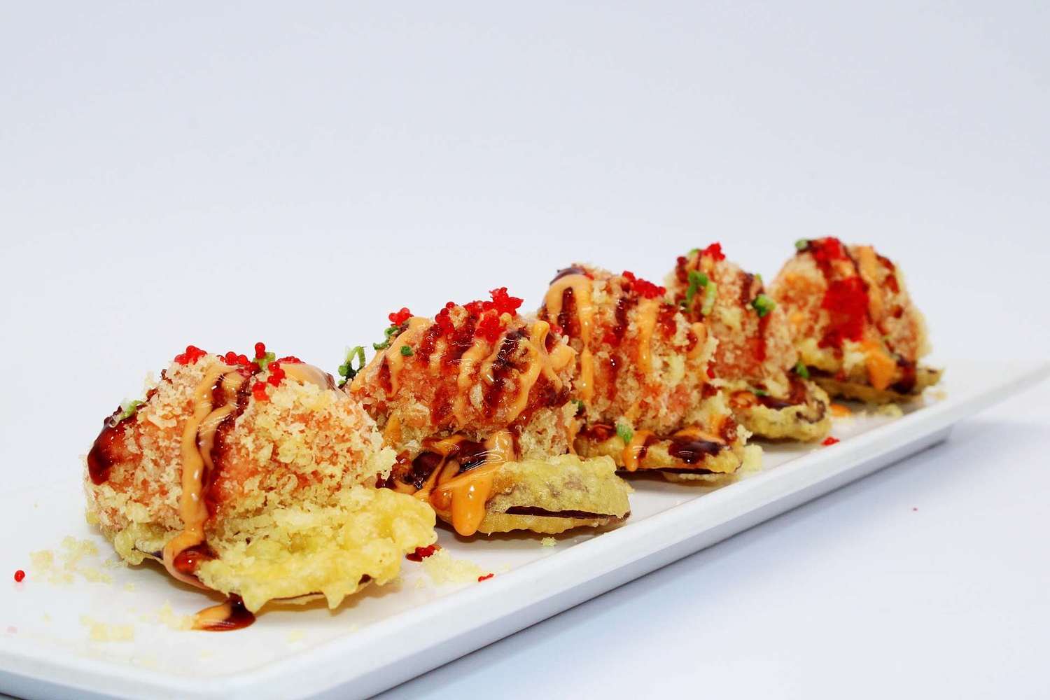Crispy tempura sushi balls drizzled with sauces at Kumamon Sushi & Ramen AYCE, a Japanese Restaurant in Wilmington