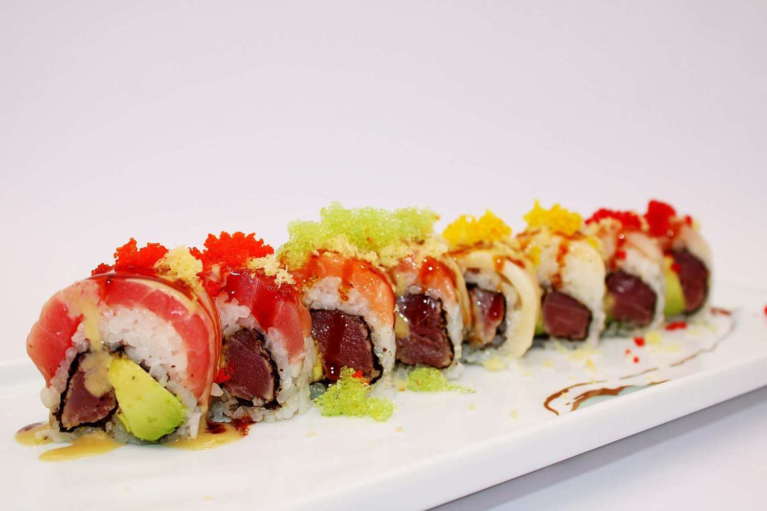 Colorful sushi roll with tuna salmon avocado and tobiko at Kumamon Sushi & Ramen AYCE, a Japanese Restaurant in Wilmington