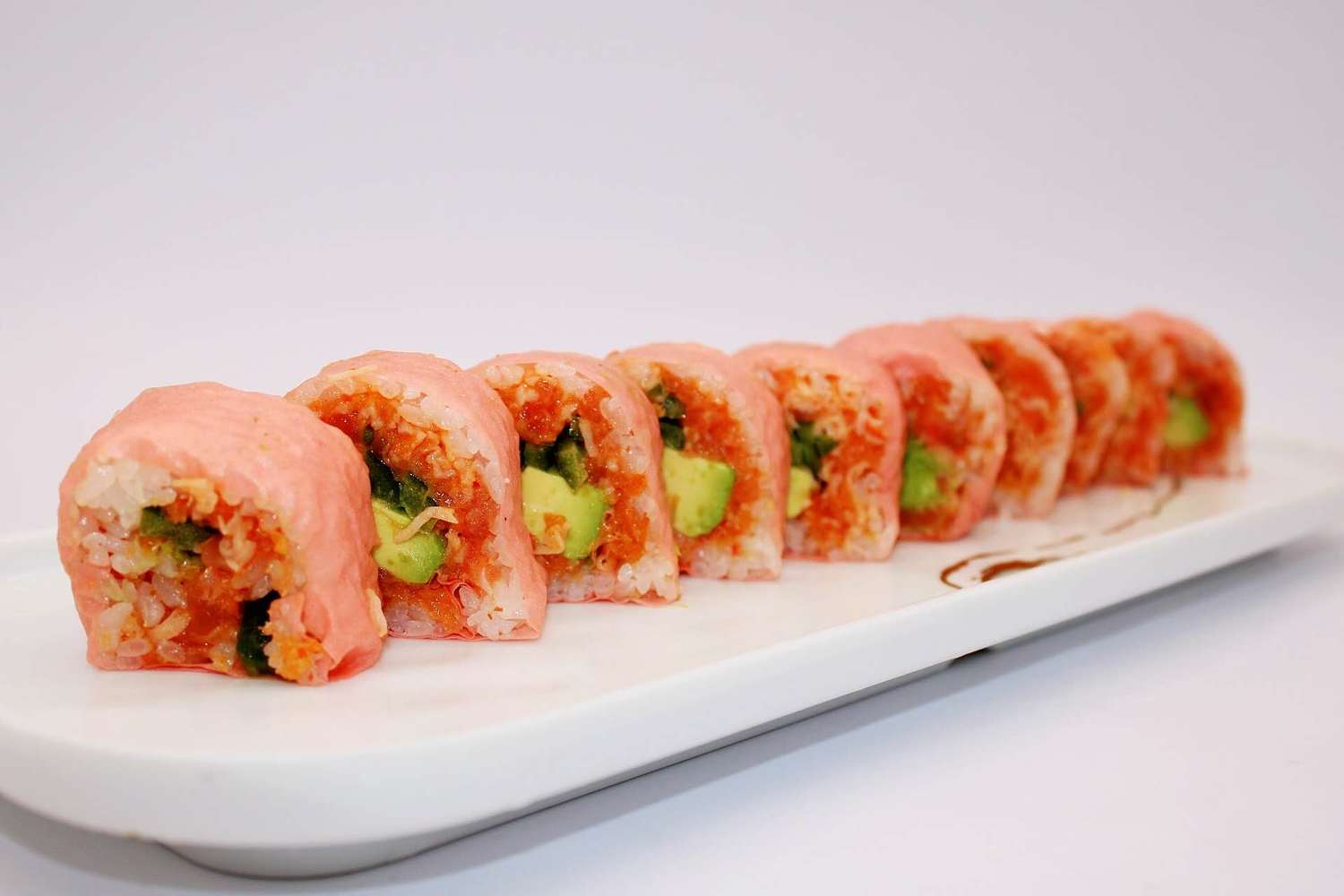 Pink cased sushi roll with avocado and spicy filling at Kumamon Sushi & Ramen AYCE, a Japanese Restaurant in Wilmington