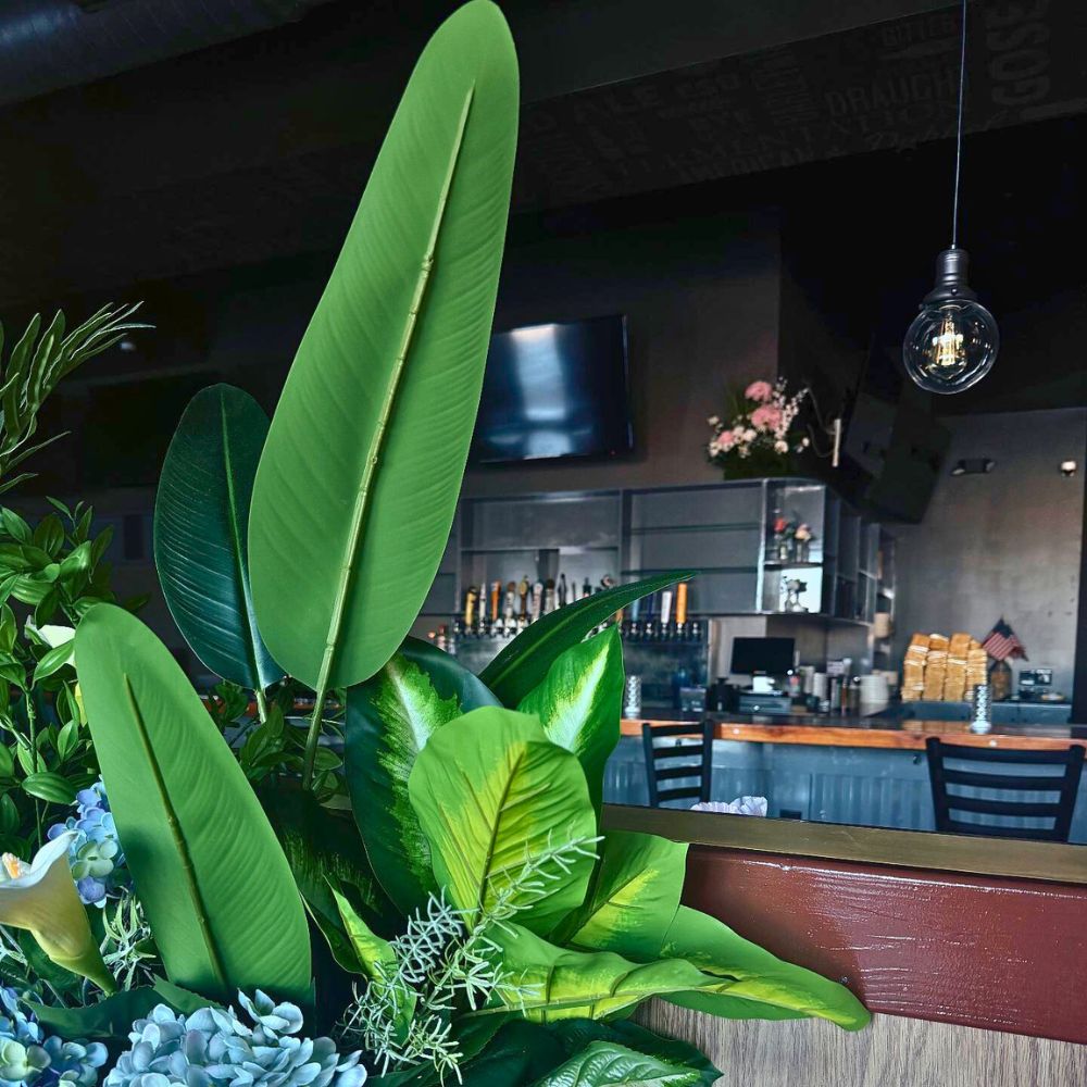Bar with green plants and TV screens at Kumo, a Japanese Restaurant in Schererville