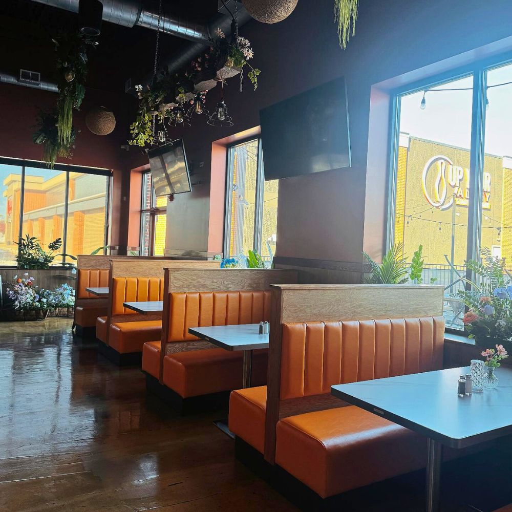 Booth seating with orange upholstery and windows at Kumo, a Japanese Restaurant in Schererville