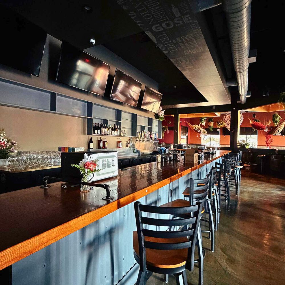 Wooden bar counter with stools and bottles at Kumo, a Japanese Restaurant in Schererville