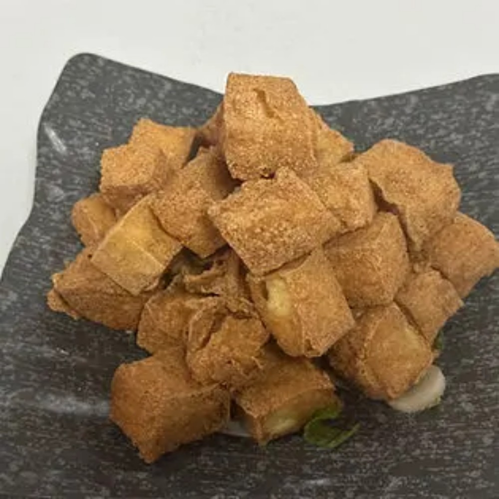 Crispy fried tofu cubes on dark square plate