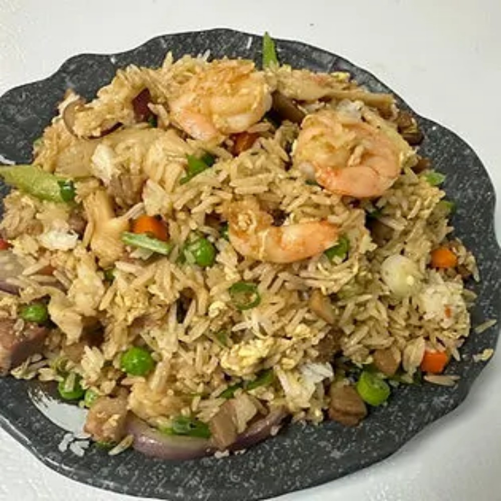 Shrimp fried rice with vegetables on dark plate