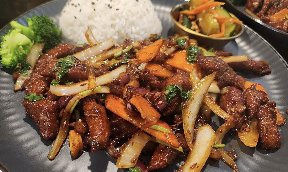 Spicy stir-fried beef with onions, carrots, rice, and broccoli at Kungfu Noodles & Dumplings, a Chinese restaurant in College Station