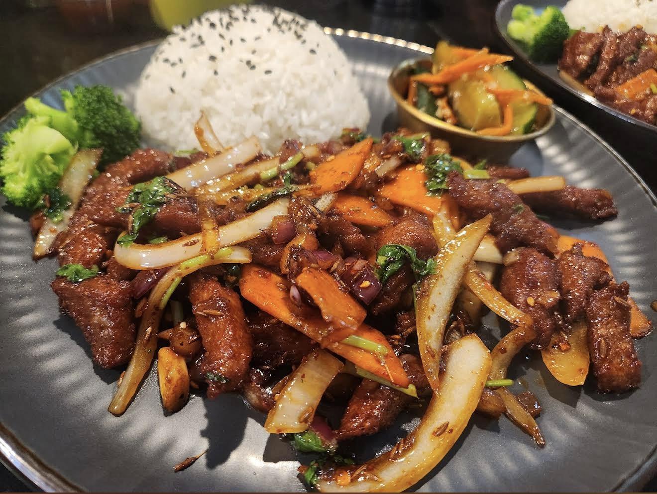 Spicy stir-fried beef with onions, carrots, rice, and broccoli at Kungfu Noodles & Dumplings, a Chinese restaurant in College Station