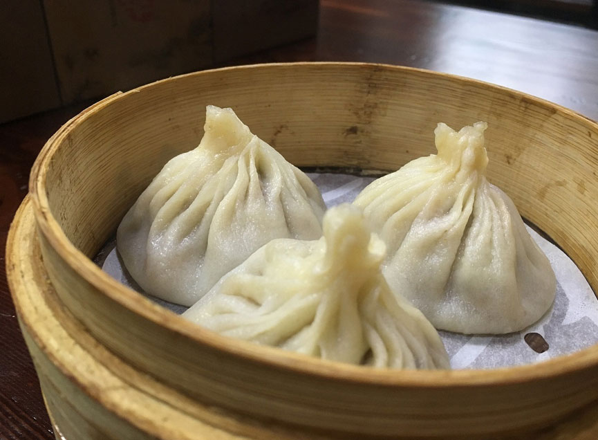 Three xiao long bao soup dumplings in bamboo steamer at Kungfu Noodles, a Ramen restaurant in Port Hueneme