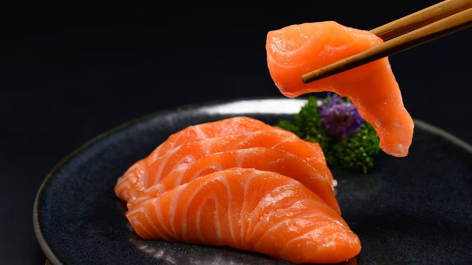 Salmon slices on a fork at Kyoto Japanese Steak House，a Japanese Restaurant in Sulphur
