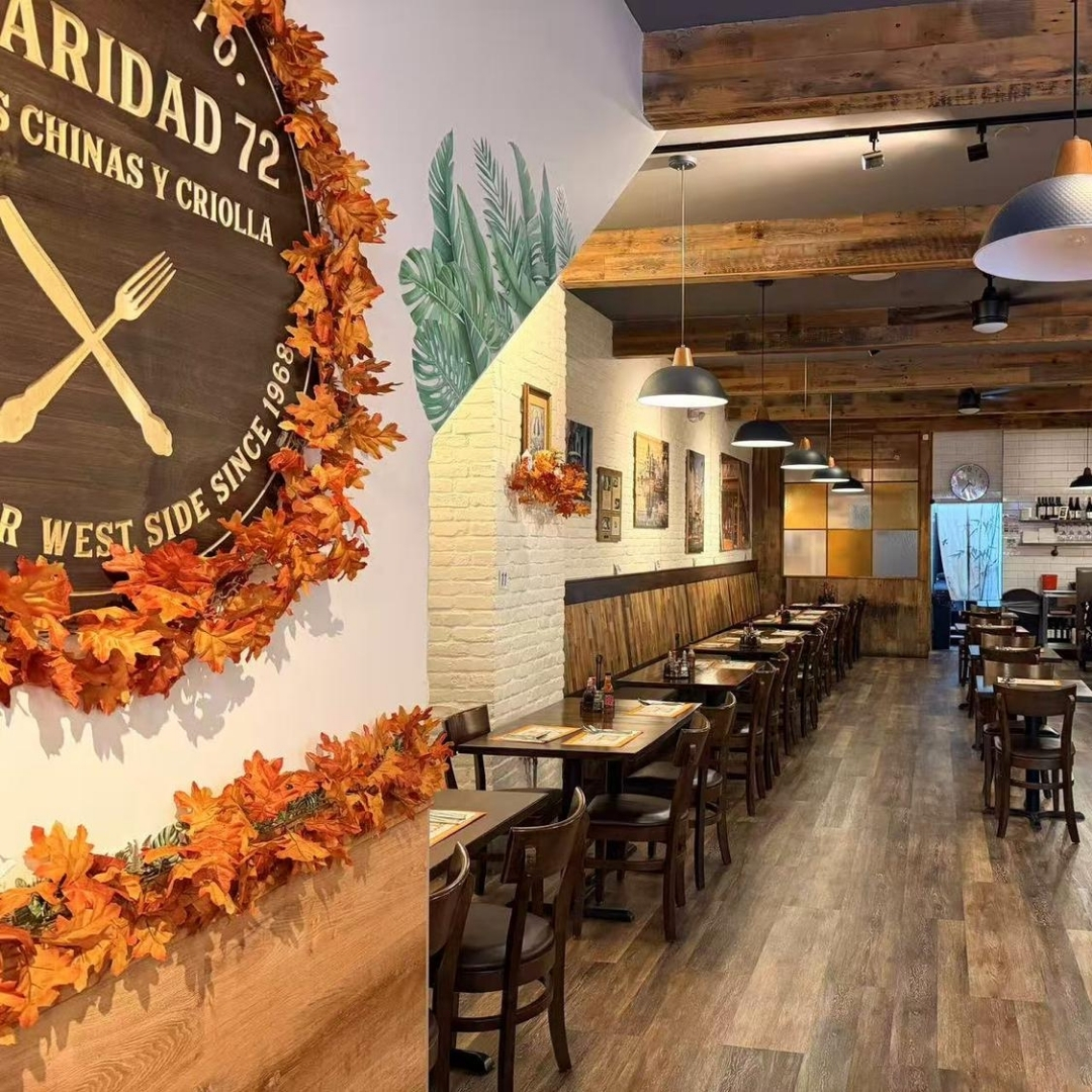 Dining space with wall sign and autumn decor at La Caridad 72, a Asian Restaurant in New York