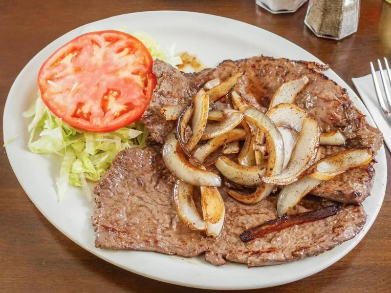 Grilled steak with onions and salad at La Caridad 72, a Asian Restaurant in New York