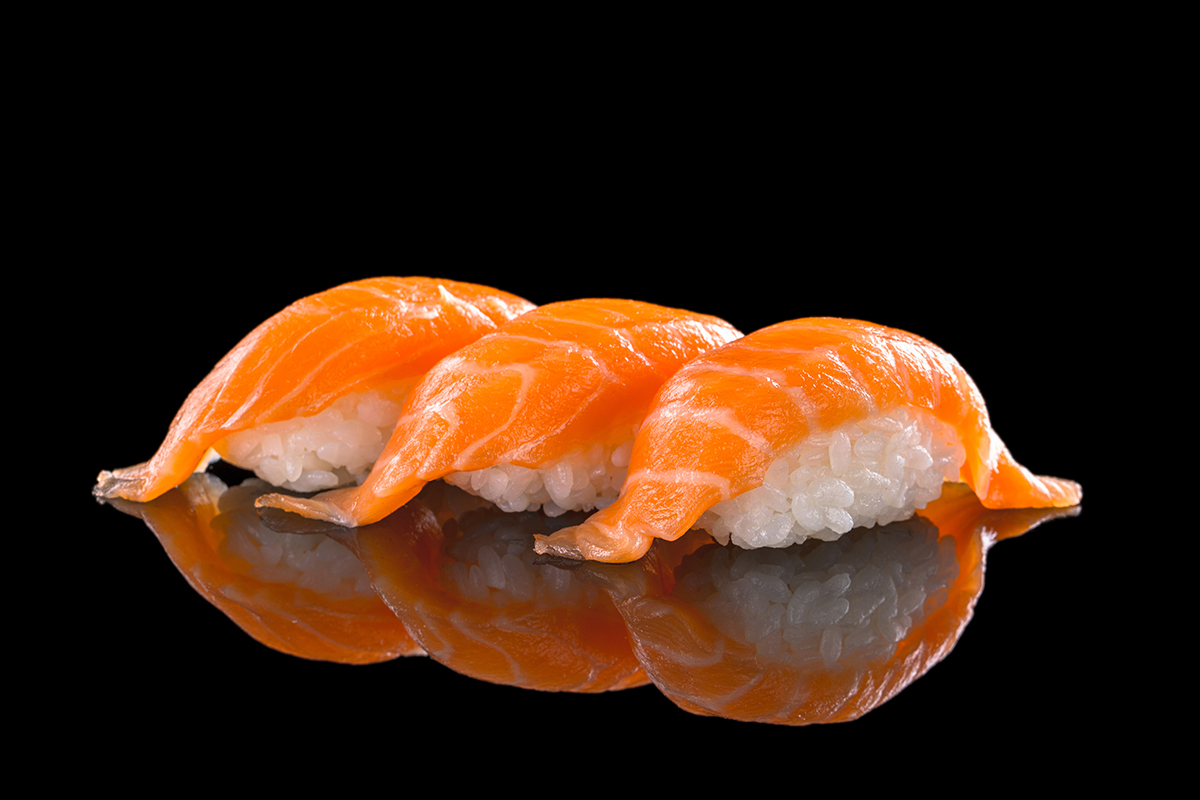 Fresh salmon nigiri sushi pieces on a black background at Osaka Sushi Bar, a Japanese Restaurant in Montgomery