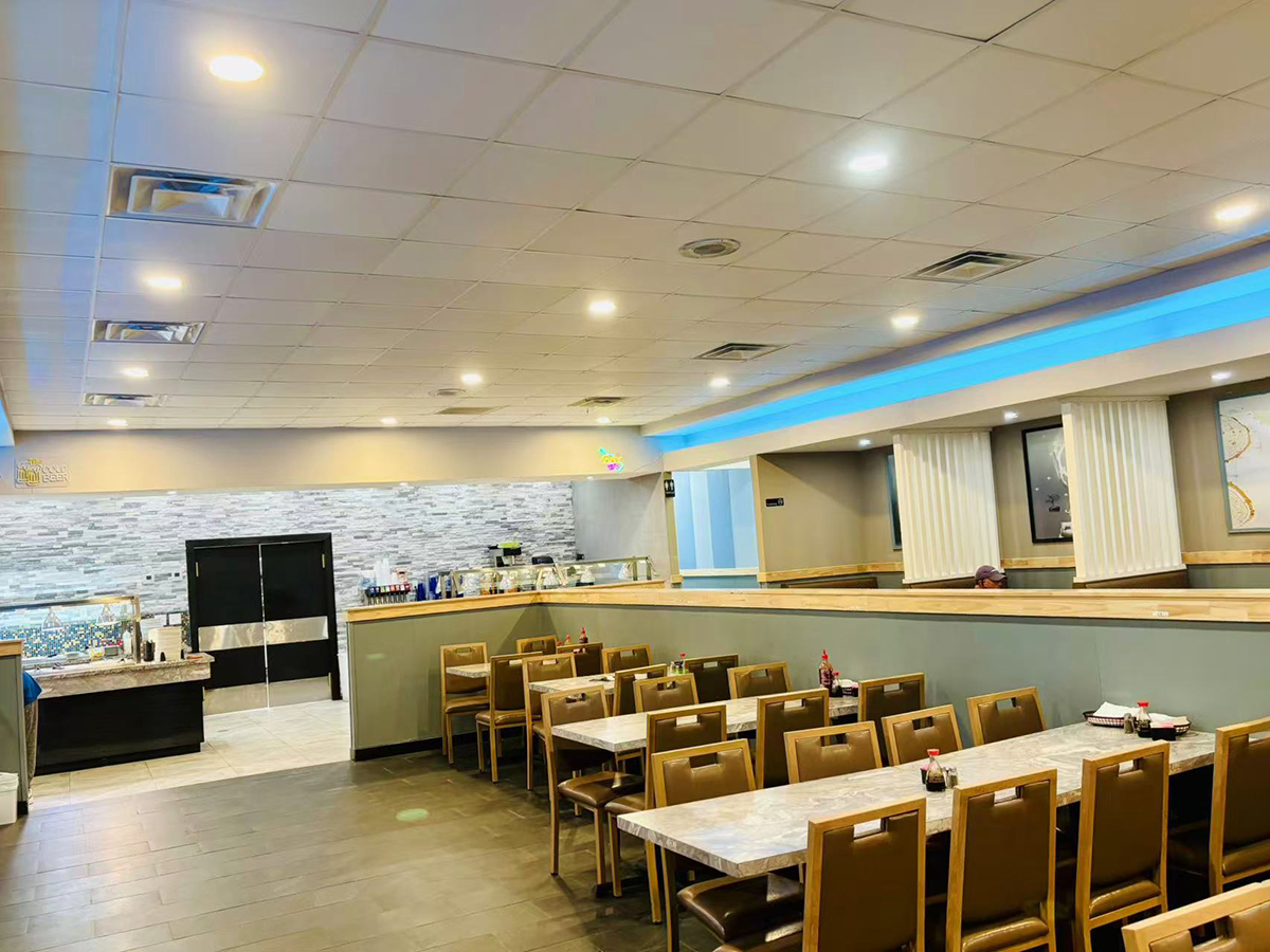 Lava-Buffet & Sushi-Asian-Fusion-Restaurant-interior-Kilgore The interior of a restaurant with neatly arranged tables and chairs, a tiled ceiling with recessed lighting, and a counter area visible in the background at Lava Buffet & Sushi,a Asian Fusion Restaurant in Kilgore