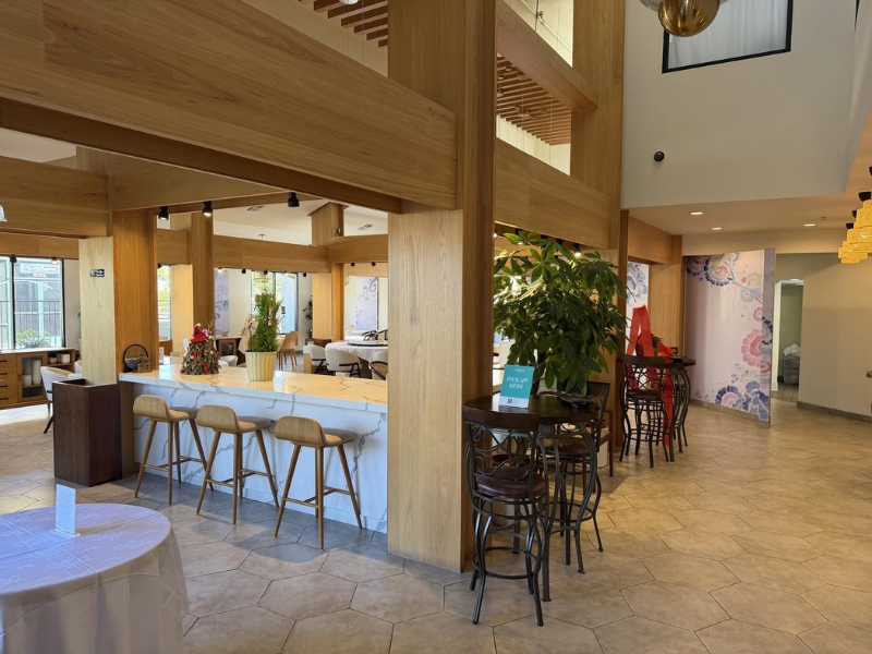 Bar seating area with wooden beams and plants at Linglong, a Chinese Restaurant in Fountain Valley.