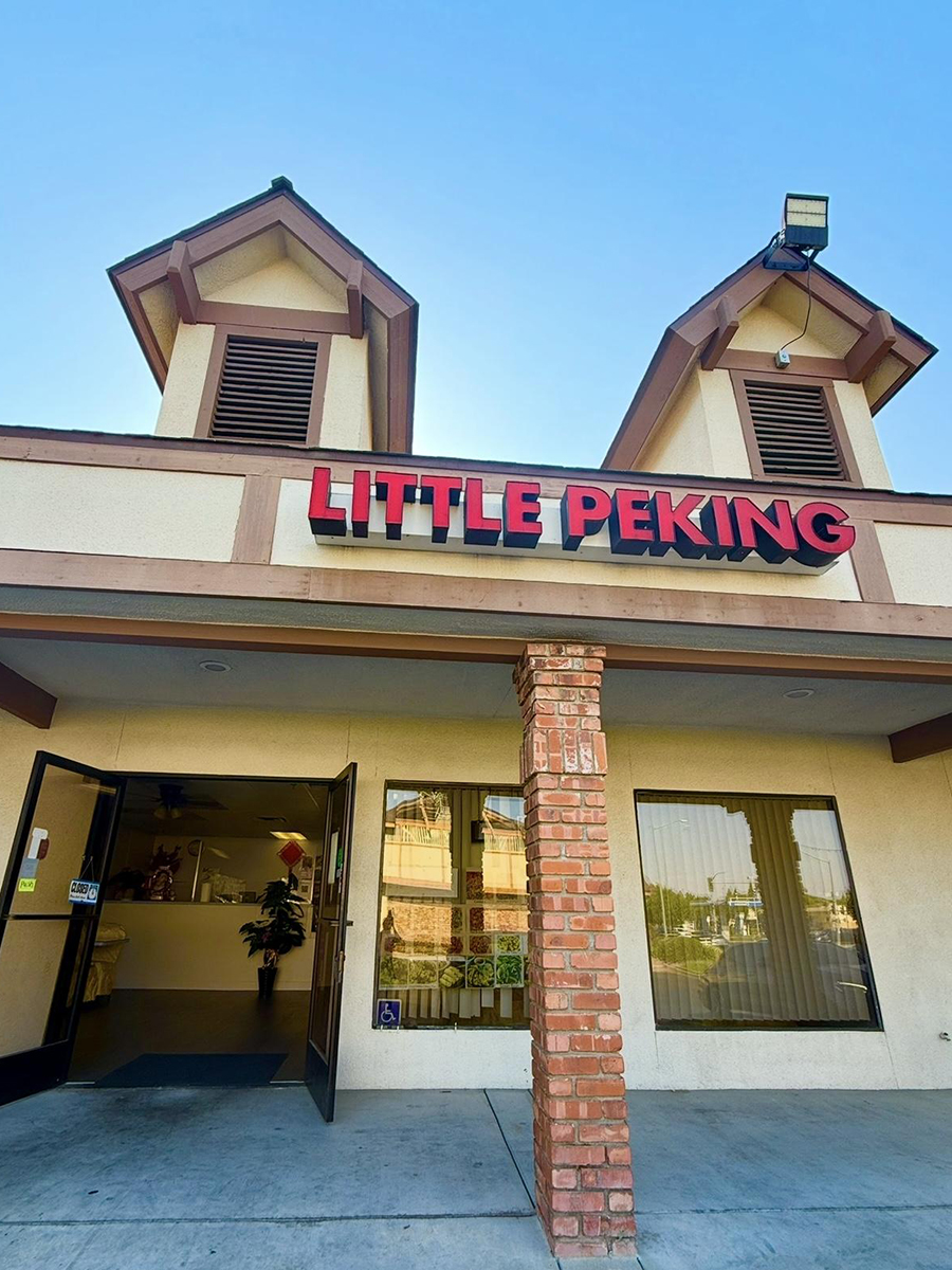 Exterior of "Little Peking" restaurant with its red sign, beige and brown architecture, and open entrance
