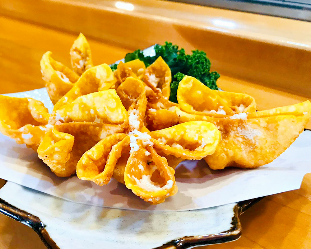Crispy Crab Wontons - Deep - fried wontons with crab filling & kale garnish at Little Tokyo (Madison), a Japanese Restaurant in Madison