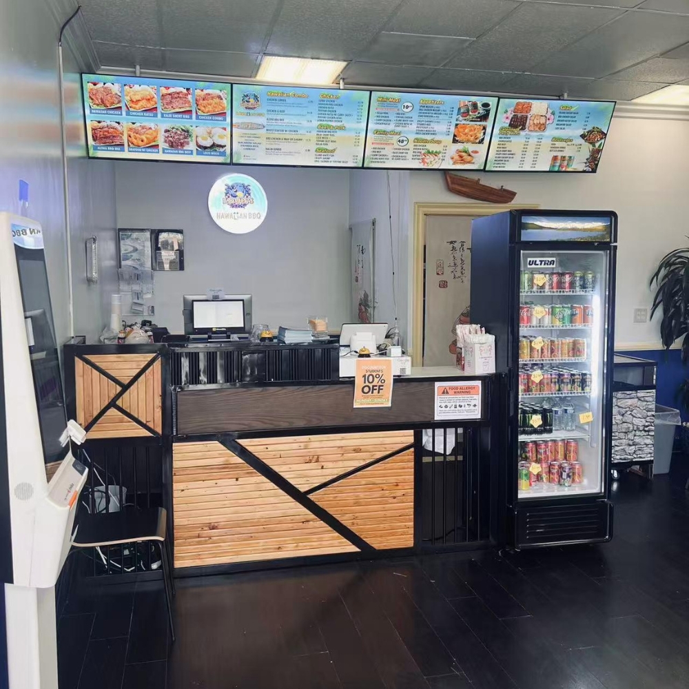 The interior counter area of Louis's Hawaiian BBQ with menu boards, a cash register, and a drink cooler at Azusa.