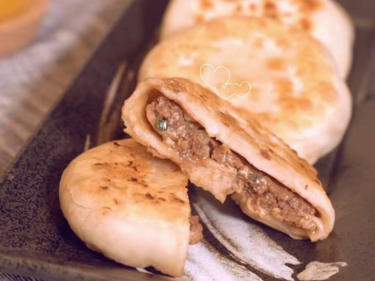 Beef pies, one cut open to show the filling at Tao's Bao，a Chinese Restaurant in Stony Brook