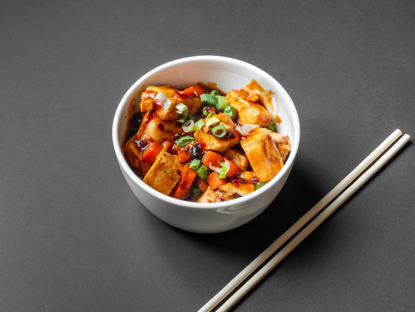 Spicy Sichuan mapo tofu topped with chopped green onion at Lucky Dragon, a Chinese Restaurant in New York