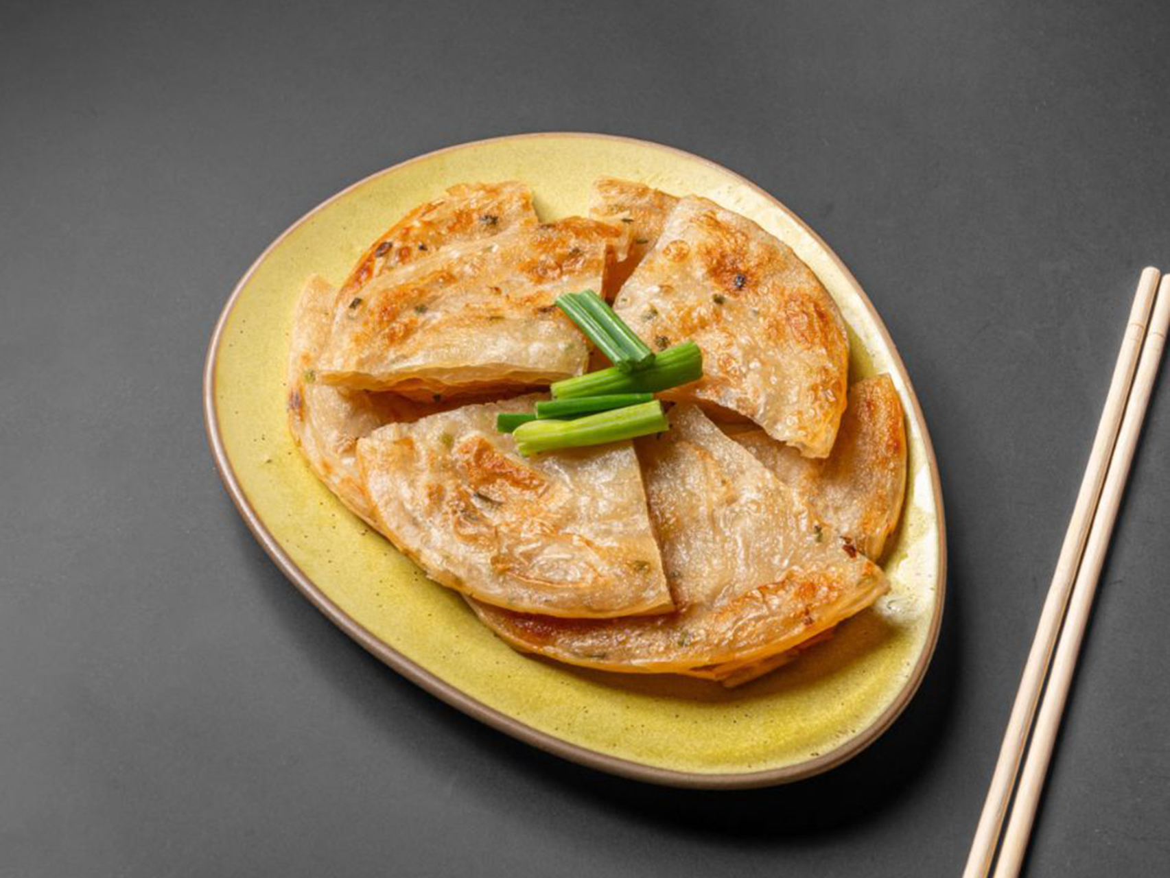 Scallion pancakes served on a yellow plate at Lucky Dragon, a Chinese Restaurant in New York