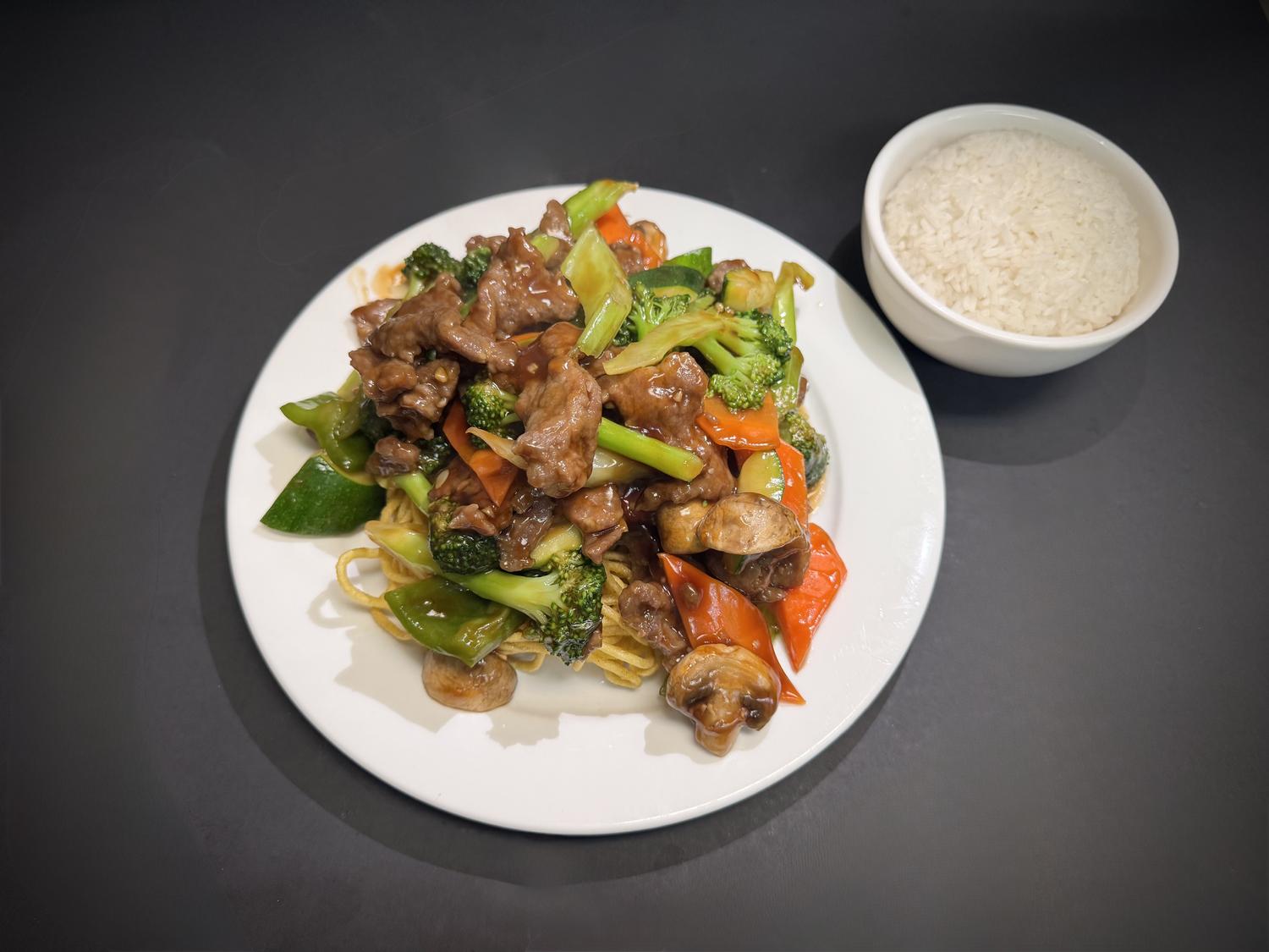 Beef stir‑fry with mixed vegetables over crispy noodles, side steamed rice at Lucky House, a Chinese restaurant in Surprise
