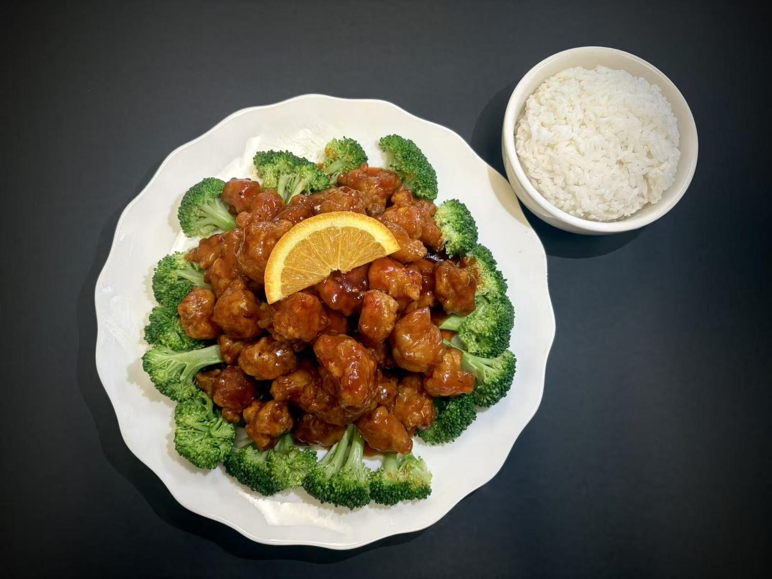 Orange glazed chicken chunks garnished with broccoli and orange slice with side rice at Lucky House, a Chinese restaurant in Surprise