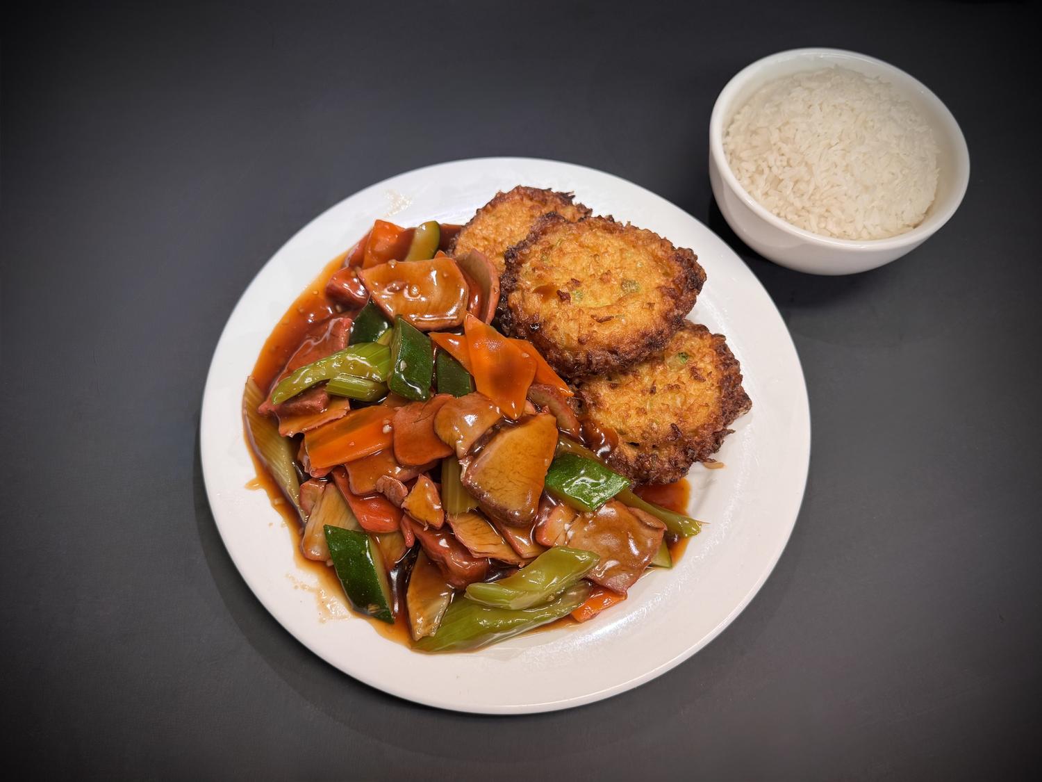 Mixed vegetable stir‑fry paired with crispy pan‑fried patties and steamed rice at Lucky House, a Chinese restaurant in Surprise