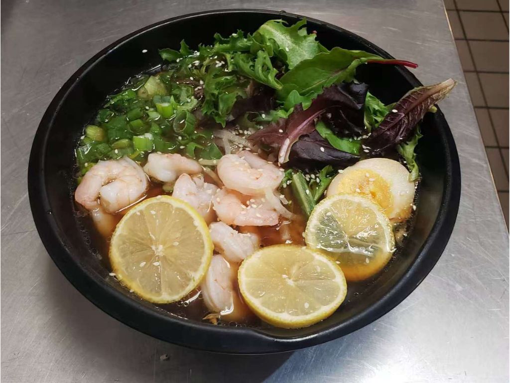 Ramen soup with plump shrimp, lemon slices, soft - boiled egg, mixed greens at Luv Ramen & BBQ, a Japanese restaurant in Hawthorne