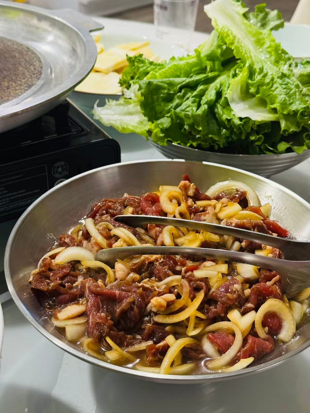 Marinated meat with onions in an iron plate, ready to cook at Lyman Meat Market, a Chinese BBQ Restaurant in Rowland Heights