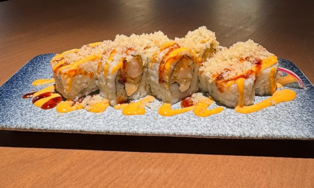 Tempura shrimp sushi roll with crispy flakes and creamy sauce at Machi Sushi, an Asian Restaurant in Houston