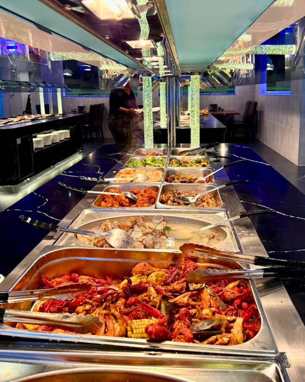 Expansive hot food buffet line with crawfish at Madness Buffet, a Buffet Restaurant in Pompano Beach