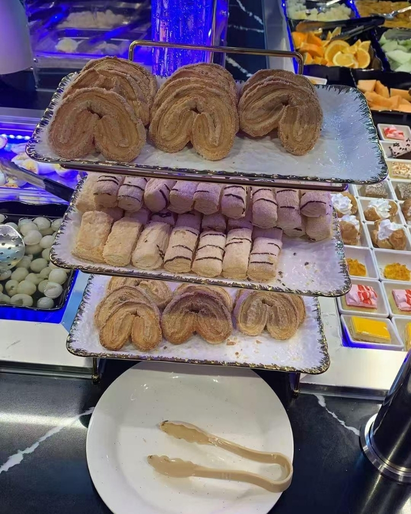 Tiered pastry display with croissants and rolls at Madness Buffet, a Buffet Restaurant in Pompano Beach