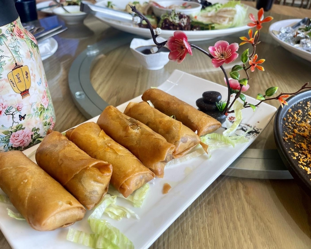 Golden fried spring rolls on white plate at Mama Chang，a Chinese Restaurant in Colmar