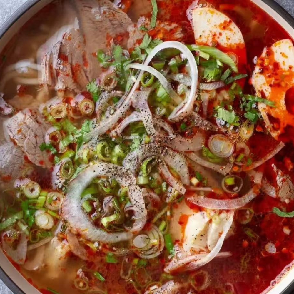 Mama-Hong’s-Pho-&-Bistro-Vietnamese-Restaurant-Spicy-Beef-Noodle-Soup-Mustang A bowl of spicy beef noodle soup with tender beef, onions, and cilantro at Mama Hong's Pho & Bistro, a Vietnamese Restaurant in Mustang.