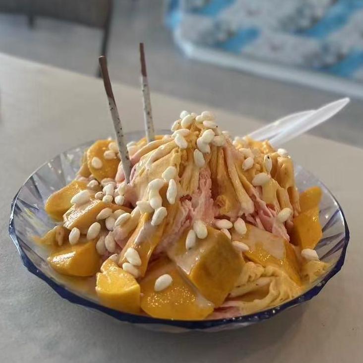 Delicious mango - flavored shaved ice topped with fresh mango chunks and white pellets at Mango Island, a Chinese Taiwanese Restaurant in Orlando