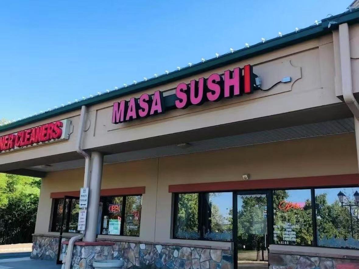 Masa Sushi Storefront The exterior of Masa Sushi with a bright sign at Masa Sushi, a Japanese restaurant in Somerville